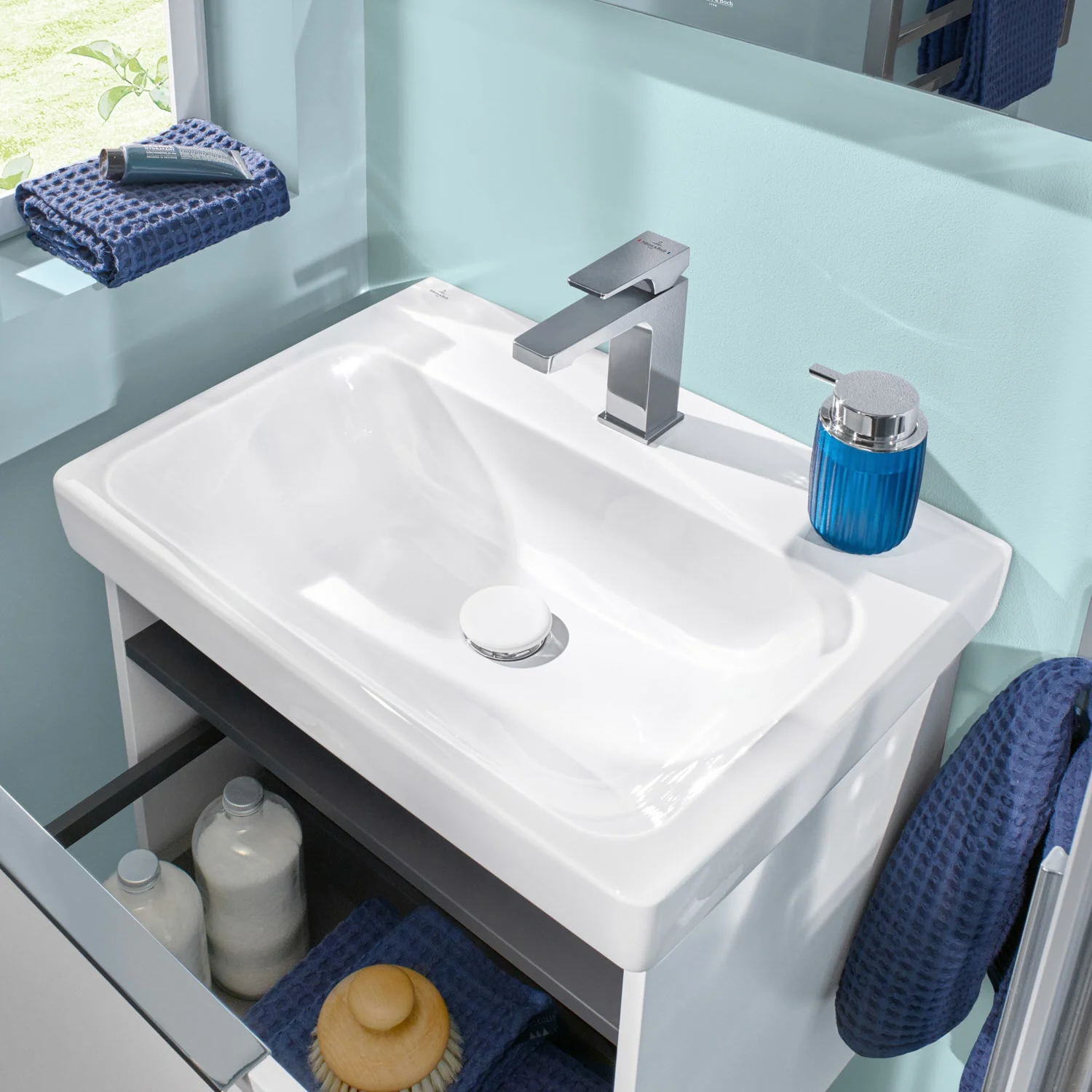 Biała umywalka z niebieskimi akcesoriami w łazience, Villeroy & Boch