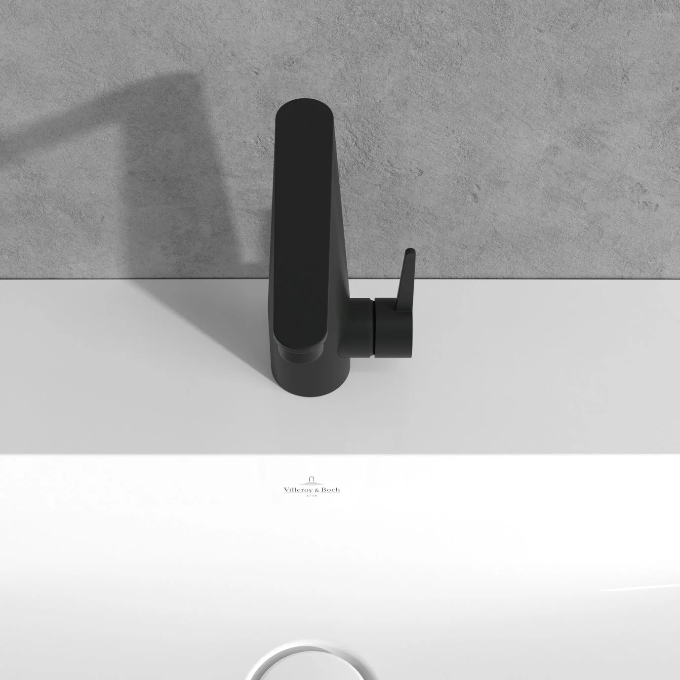 Czarna bateria z boku nad białą umywalką, Villeroy & Boch
