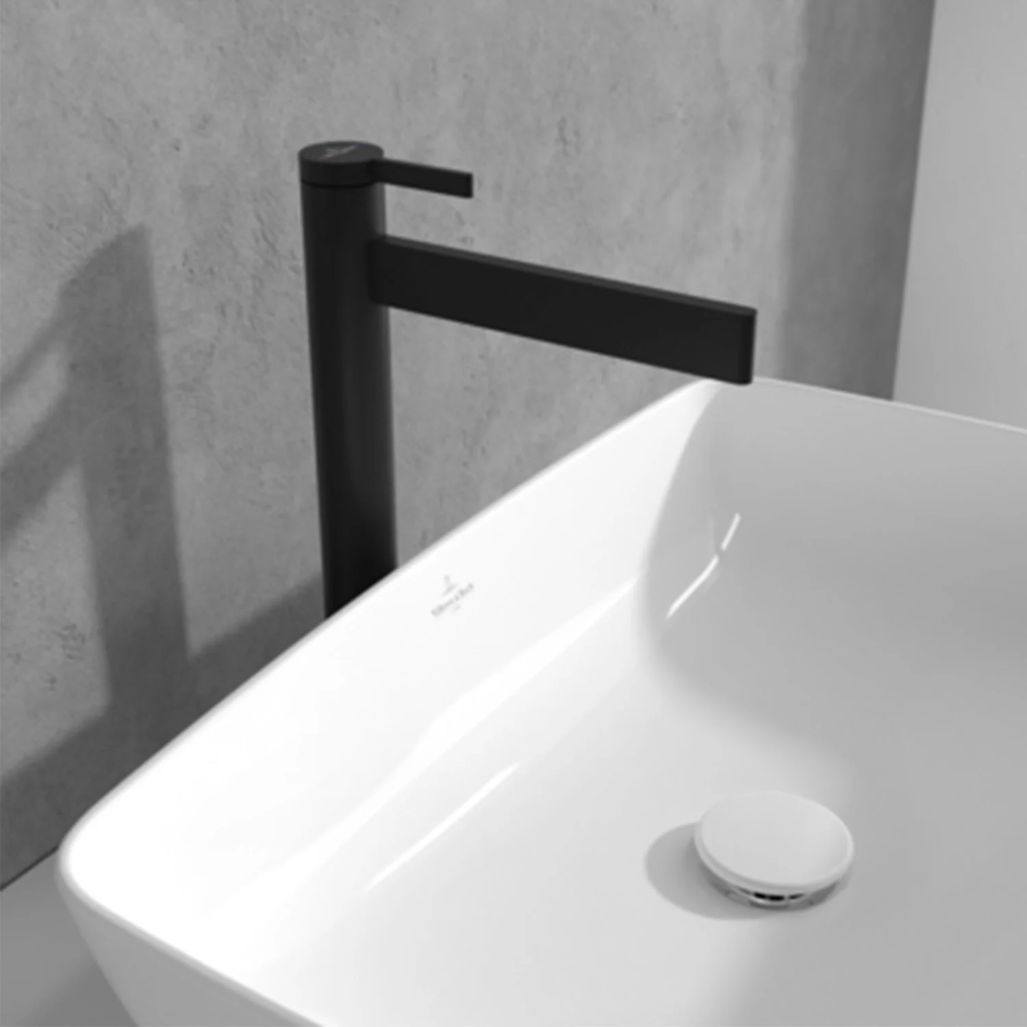 Czarna bateria obok prostokątnej umywalki, Villeroy & Boch