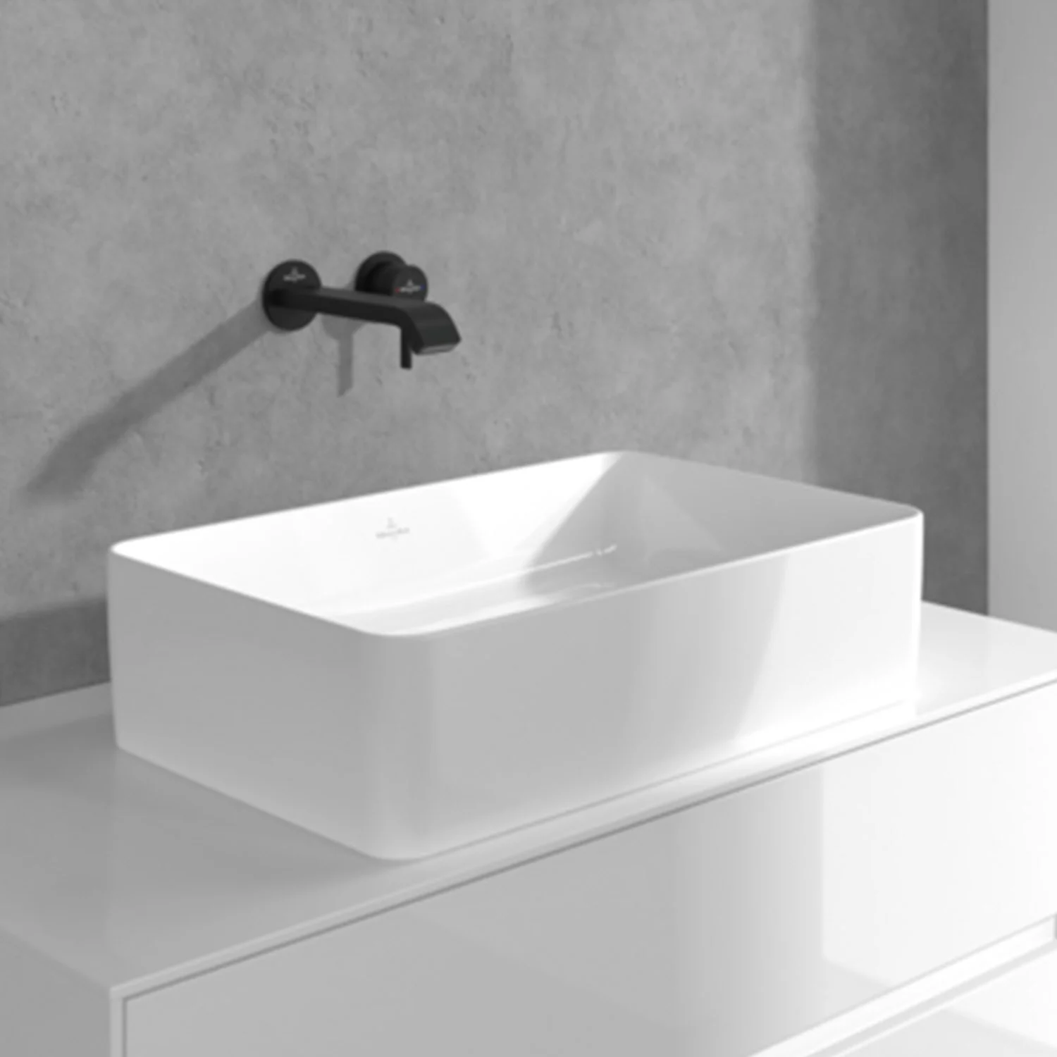 Czarna bateria ścienna nad białą umywalką, Villeroy & Boch