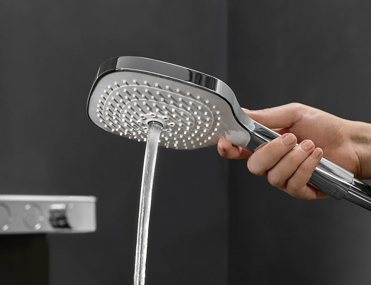 Ręka trzymająca słuchawkę prysznicową z wodą, Villeroy & Boch