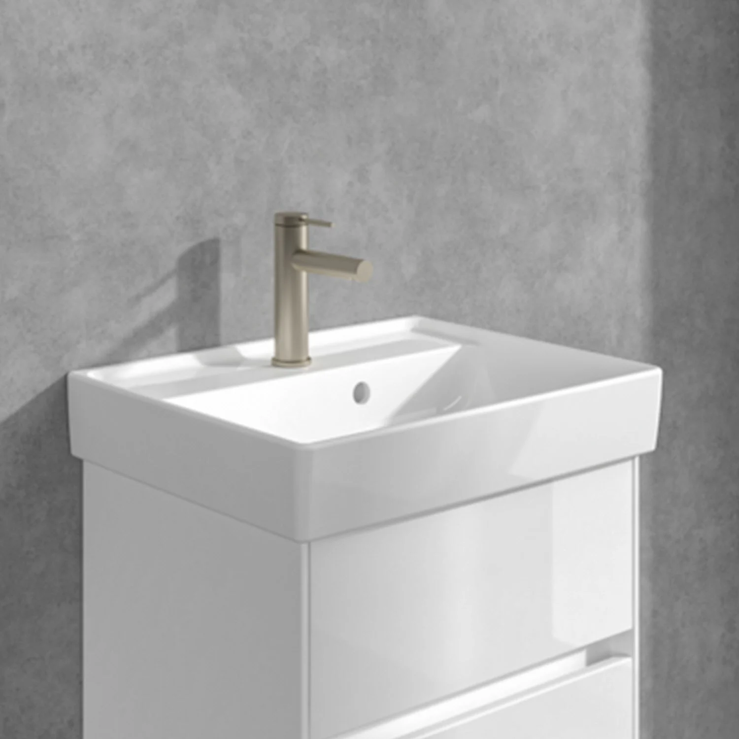 Umywalka ze złotą baterią na tle szarej ściany, Villeroy & Boch
