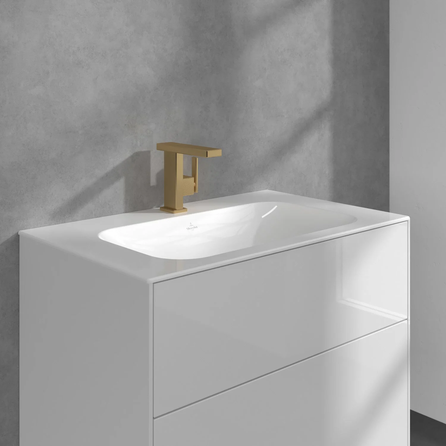 Zbliżenie na umywalkę ze złotą baterią, Villeroy & Boch
