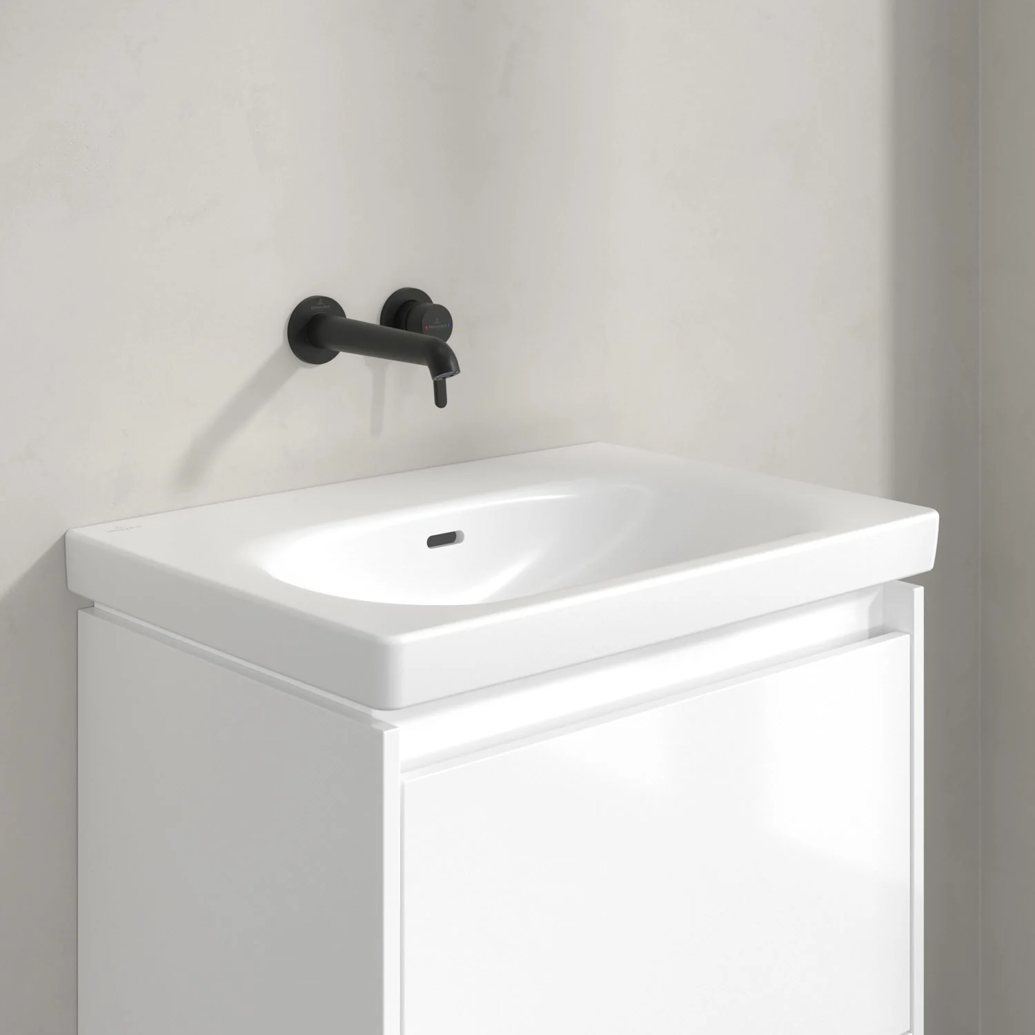 Czarna bateria ścienna nad białą umywalką, Villeroy & Boch