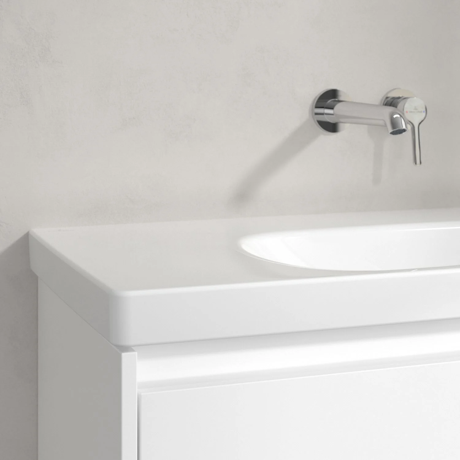 Zbliżenie białej umywalki z kranem ściennym, Villeroy & Boch