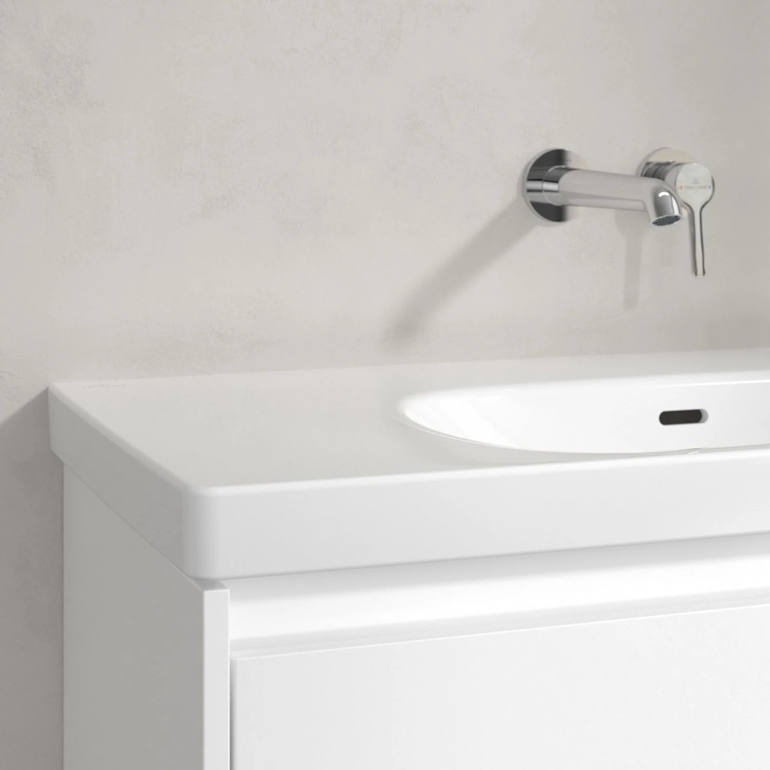 Zbliżenie białej umywalki z kranem ściennym, Villeroy & Boch