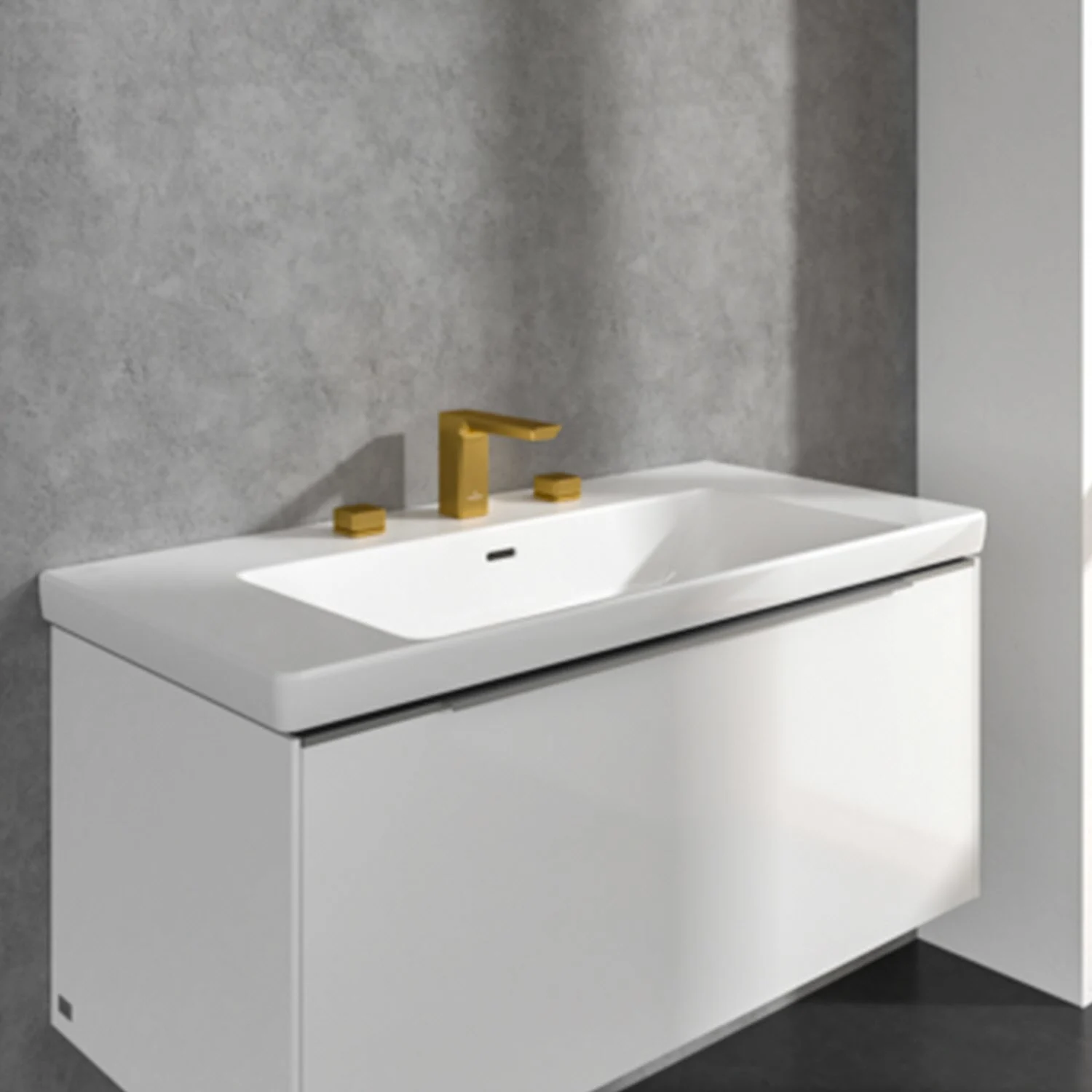 Zbliżenie na szeroką umywalkę ze złotą baterią, Villeroy & Boch