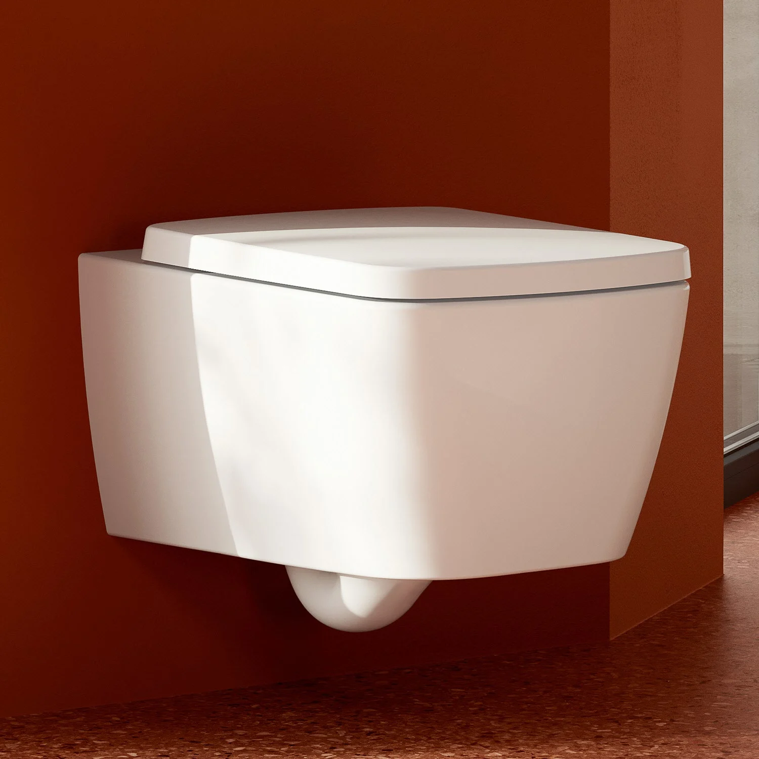 Zbliżenie białej toalety ściennej na tle czerwonej ściany, Villeroy & Boch