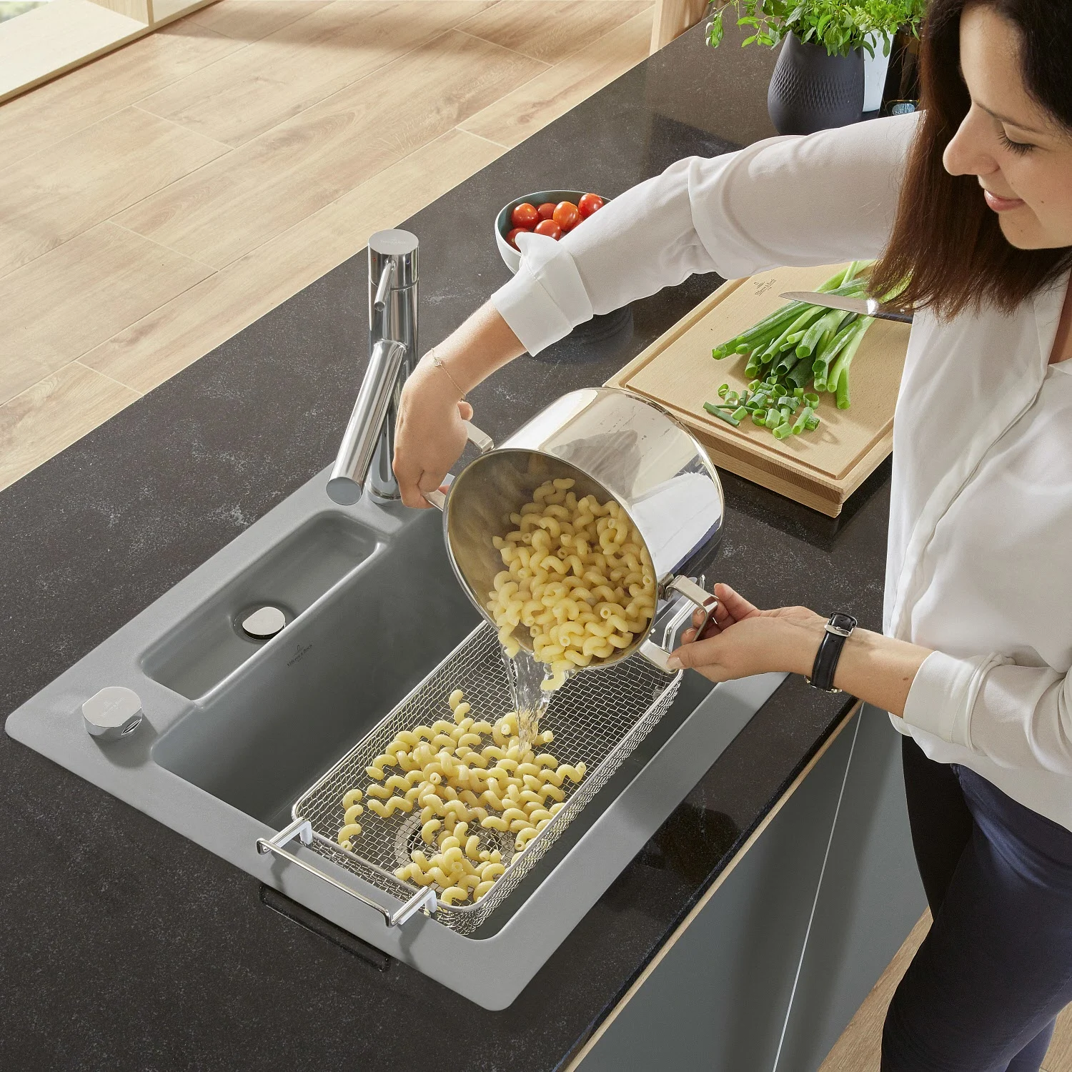 Kobieta wlewa makaron do szarego zlewu, Villeroy & Boch