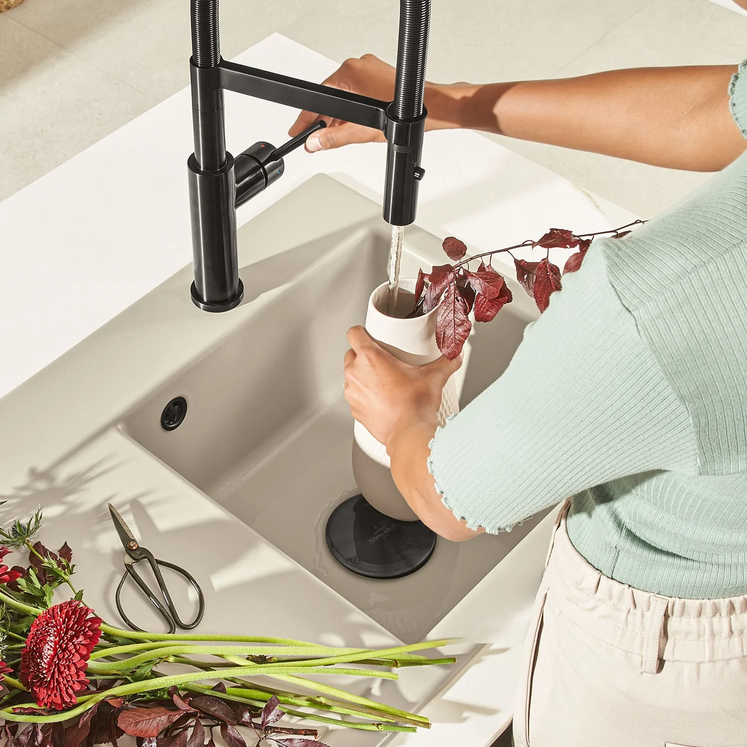 Osoba napełnia wazon wodą w ceramicznym zlewie, Villeroy & Boch