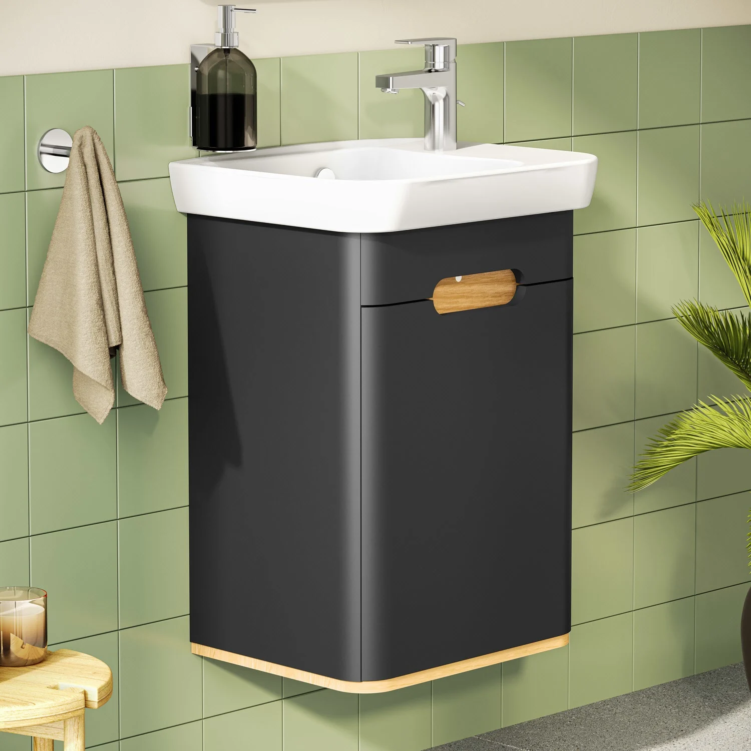 Czarna umywalka z baterią na tle zielonej kafelkowej ściany, Vitra