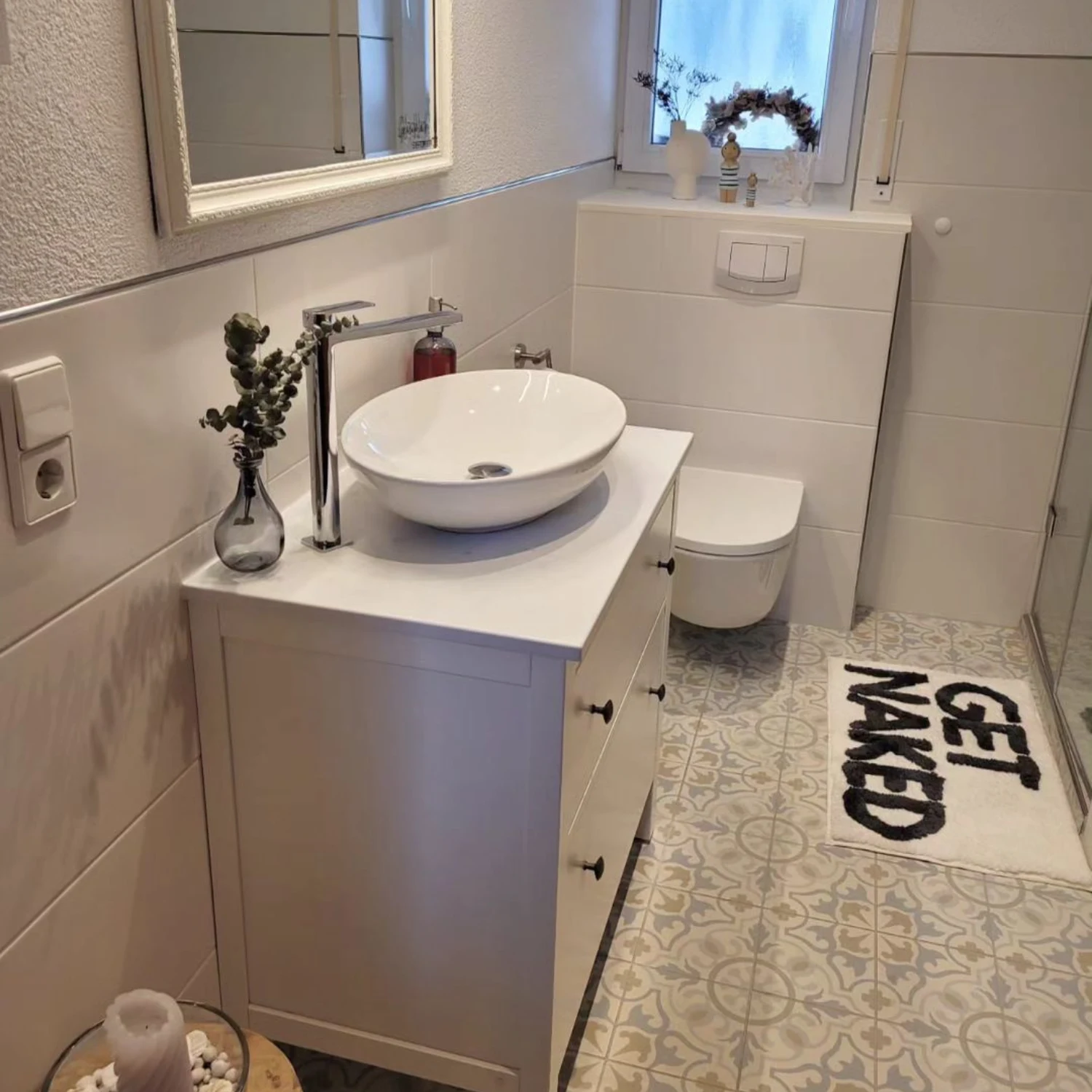 kleines, weißes Badezimmer mit weißen Badmöbeln und Dekoelementen