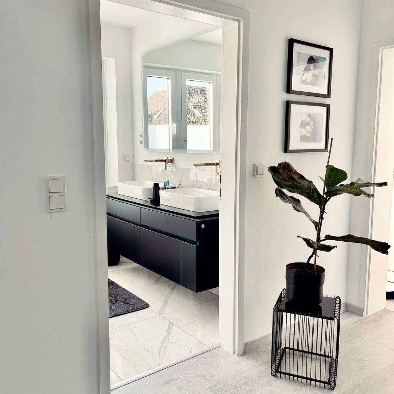 Einblick vom Flur in ein schwarz-weiß gestaltetes Bad