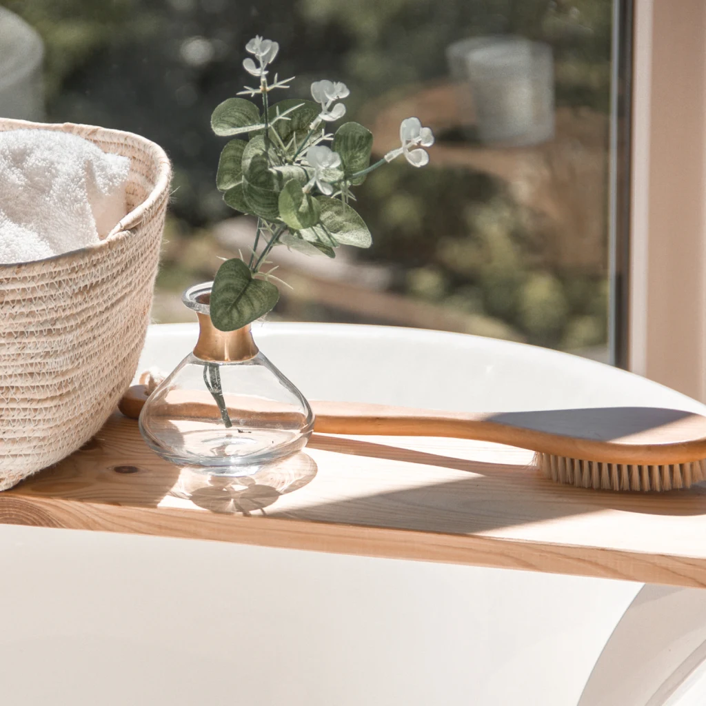 beige Aufbewahrungsbox neben Bürste und Minivase auf einem Regalholz