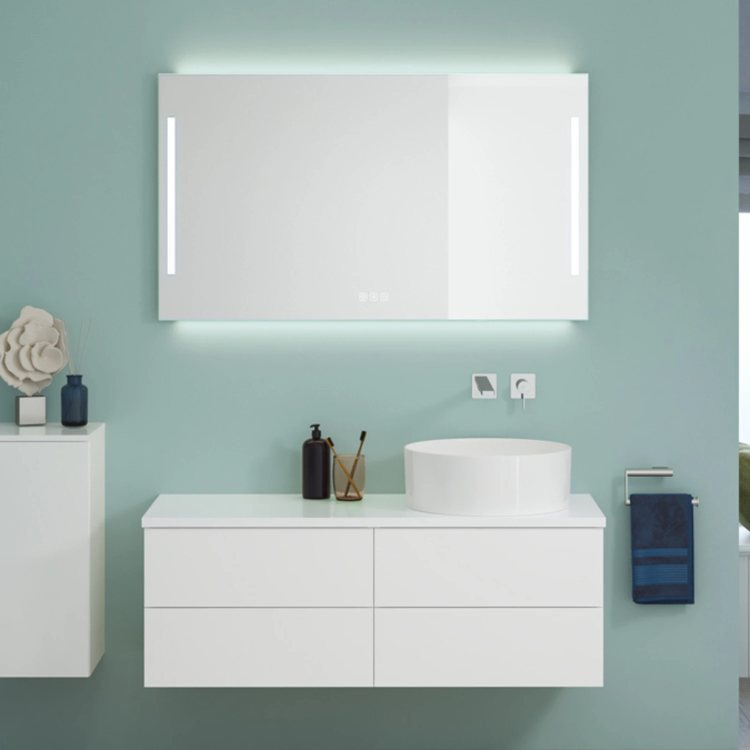 Weißer Waschtisch mit beleuchtetem Spiegel vor türkiser Wandfarbe