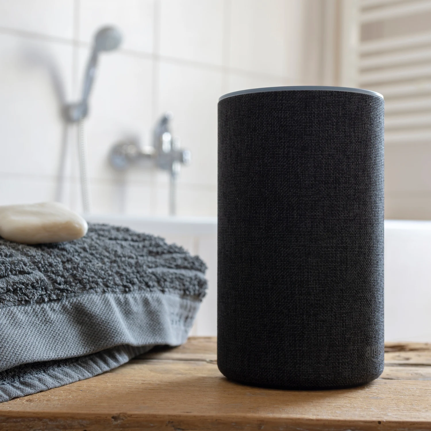 Musikbox neben Handtuch im Badezimmer mit Armaturen im Hintergrund