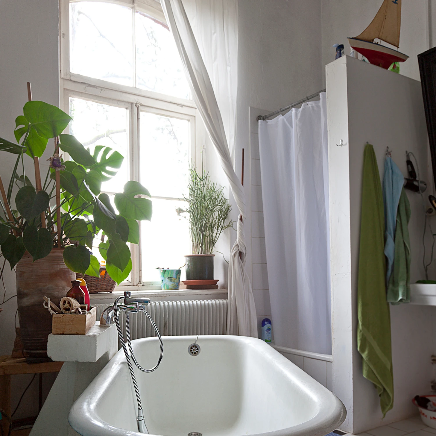 Badezimmer im Altbau-Charme mit hohen Decken und langen Gardinen