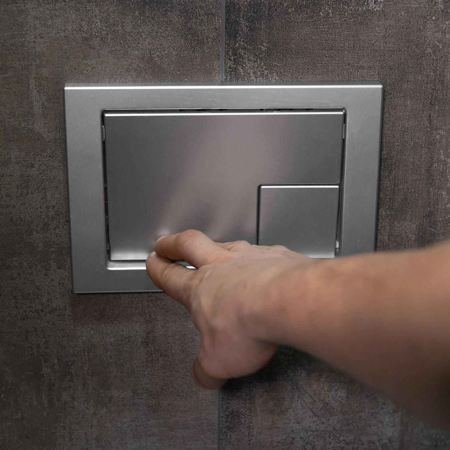 Eine Person betätigt eine Druckspülung