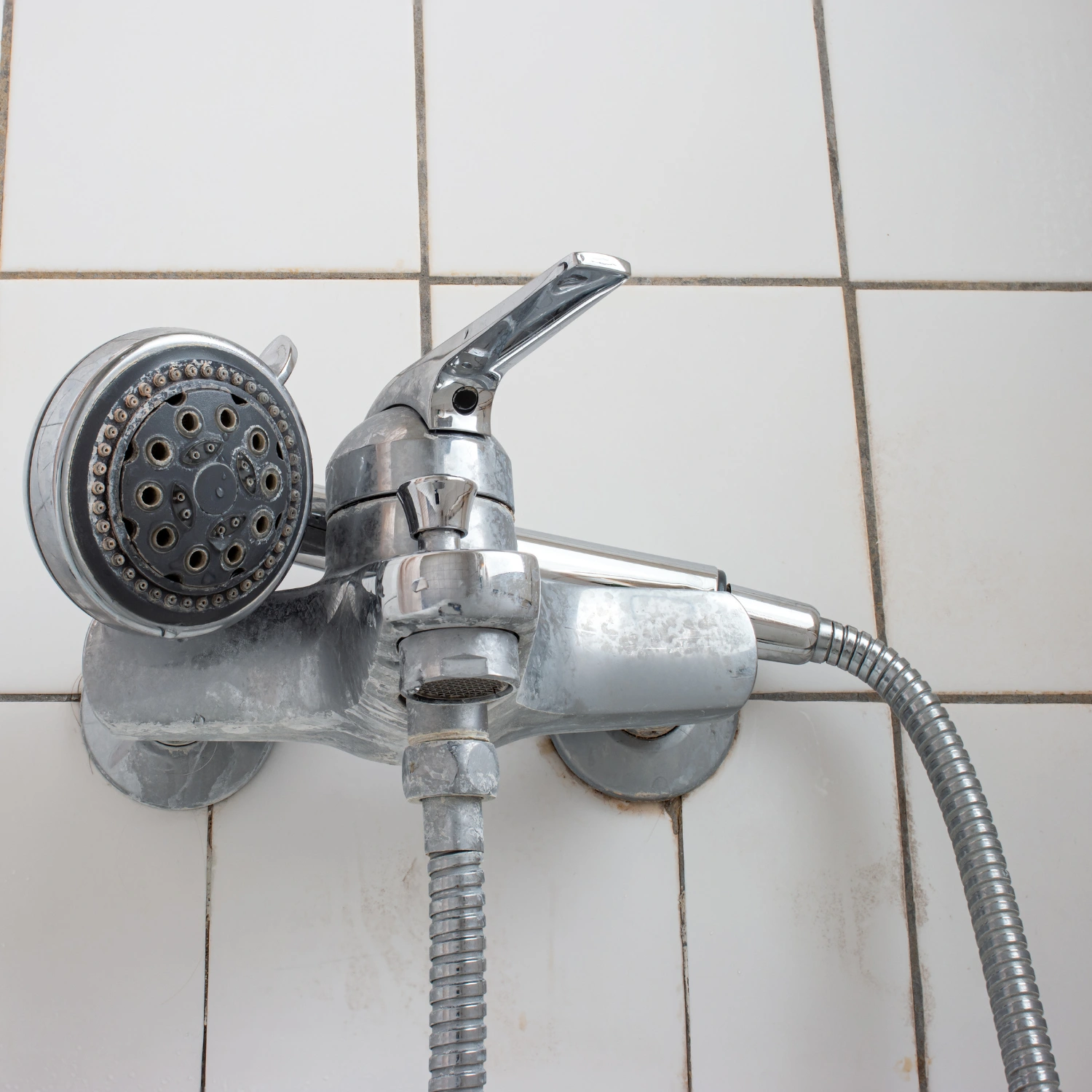 Alte, verkalkte Badewannenarmatur mit Duschkopf