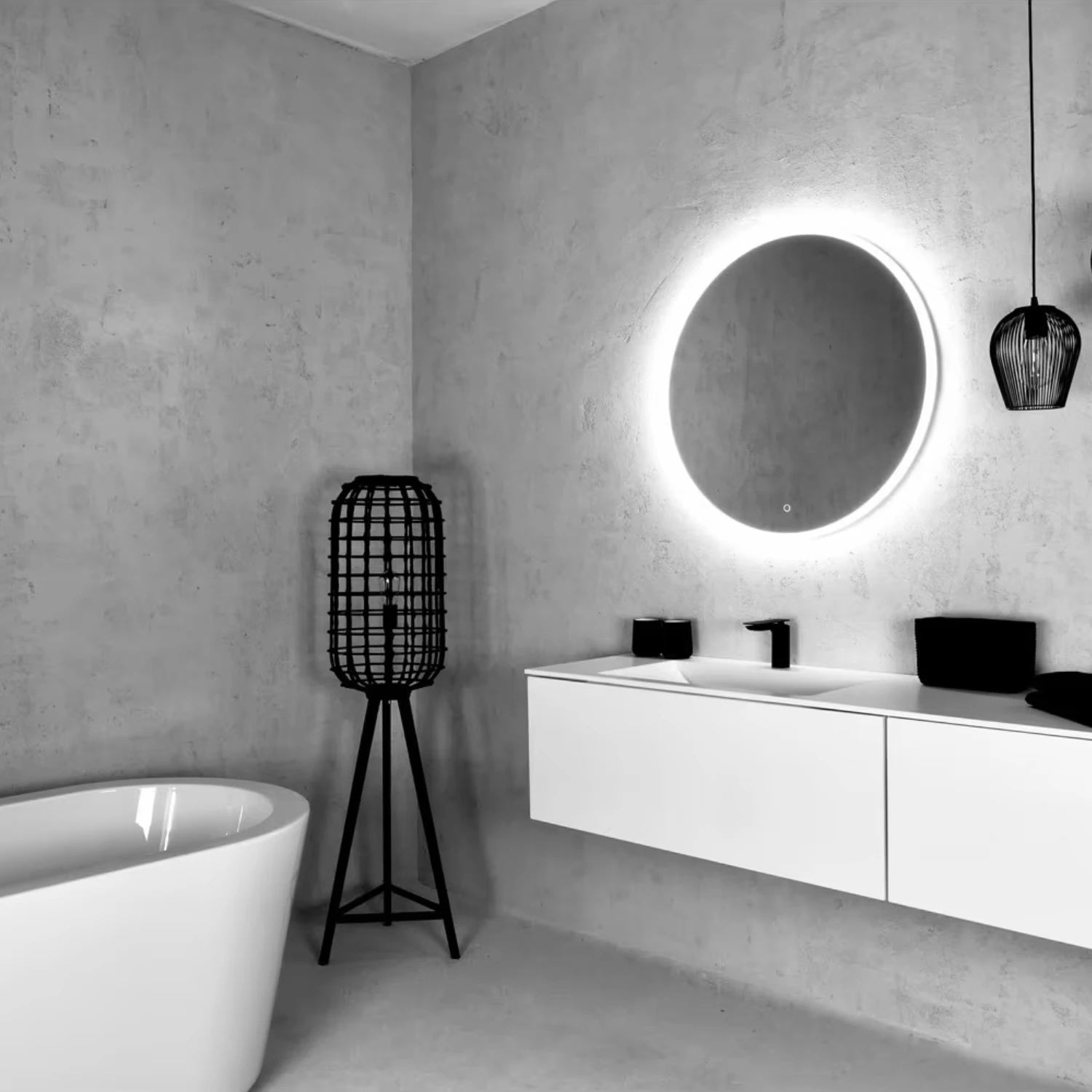 Modernes Bad mit strukturierter Natursteinoptik, runder LED-Spiegel und skulpturalen Akzenten.