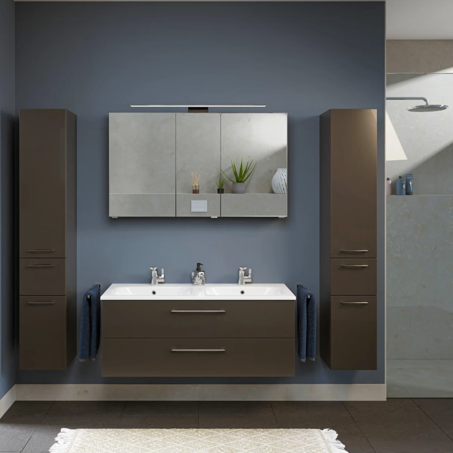 Steinkamp Joy 2.0 Doppel-Waschtischunterschrank in einem dunkeln Bad mit einer dunkelblauen Akzentwand.