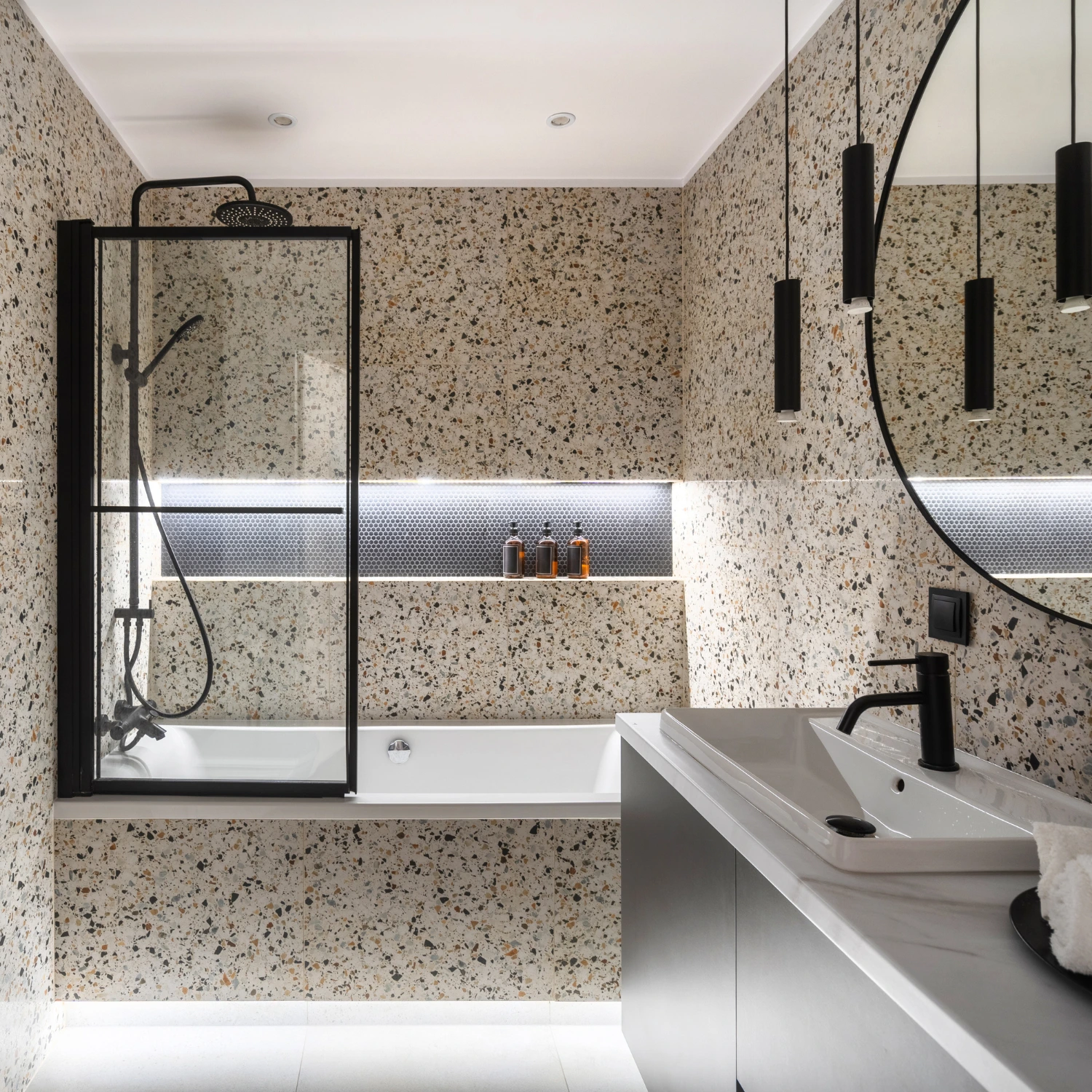 Luxuriöses Badezimmer mit auffälligen Terrazzowänden in einem hellen Beige.