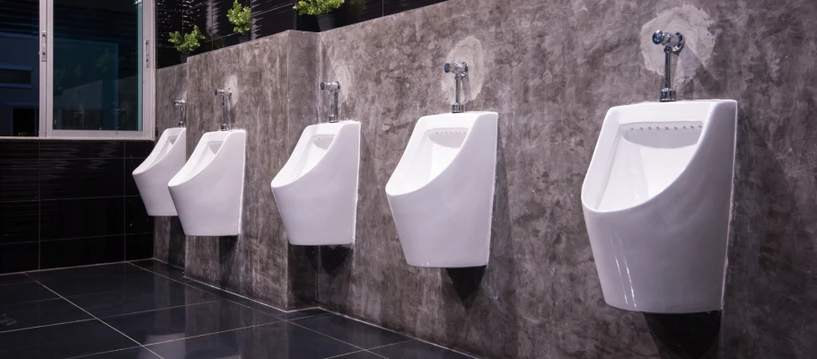 Weiße Wandurinale in einer öffentlichen Toilette